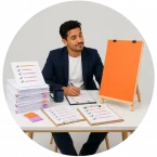 A man looking at paperwork showing lots of project activity but no real progress toward the goal.